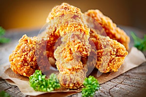 Crispy fried chicken wings on wooden table