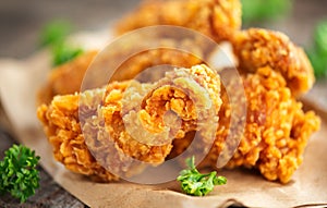 Crispy fried chicken wings on wooden table