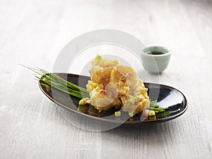 Crispy fried Crystal Prawns tossed with Salted Egg Yolk with chopsticks served in a dish isolated on mat side view on grey