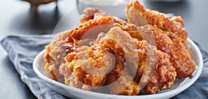 Crispy fried korean chicken wings in soy garlic sauce with pickled radish and kimchi sides photo