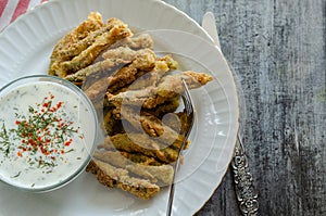 The crispy fried okra in container and spicy yogurt sauce