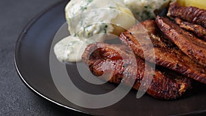 Crispy fried pork with creamy parsley sauce and boiled potato in the plate on the table or stegt flÃ¦sk