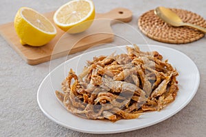 Crispy fried small fish on white plate