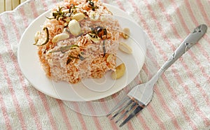 Crispy fried thin rice noodles with coconut cream topping peanut and slice lemon leaf on plate