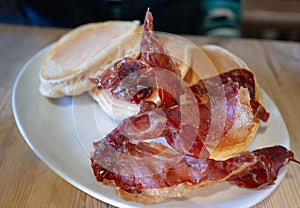 Crispy ham and pancakes on a white oval plate