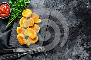 Crispy homemade baked chicken nuggets. Dark background. Top view. Copy space