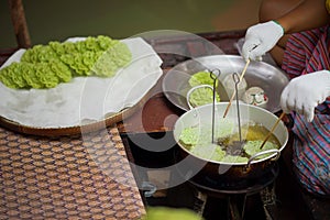 Crispy Lotus Blossom Cookie Kanom Dok Jok Fried with oil in a pan.