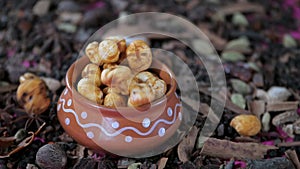 Crispy lotus pop seeds falling inside an earthen pot full of Makhana - healthy snack