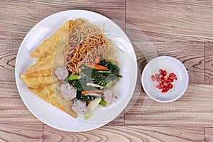 Crispy noodle topped kale soup with meatball