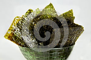 Crispy nori seaweed on bowl. Traditional Japanese dry seaweed sheets.