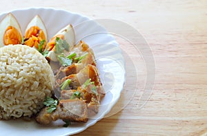 Crispy pork with eggs which boiled in Chinese style gravy and brown rice in white plate