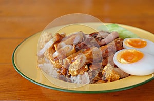 Crispy pork rice with boiled egg in a light yellow dish