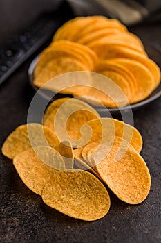 Crispy potato chips on black table