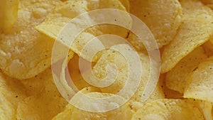 Crispy potato chips rotating close-up. Golden fried potatoes in macro.