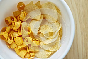 Crispy potato chips in white bowl