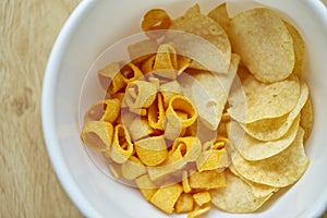 Crispy potato chips in white bowl