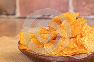Crispy potato chips on wooden bowl