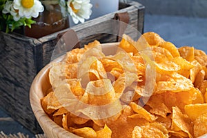 Crispy potato chips on wooden bowl