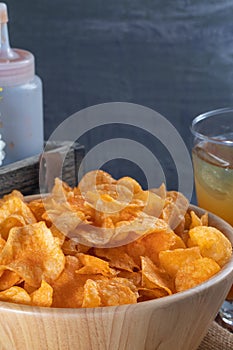 Crispy potato chips on wooden bowl