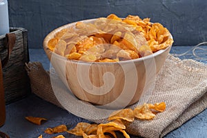 Crispy potato chips on wooden bowl