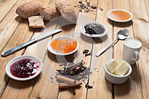 Crispy rolls with butter, apple and berry jam for breakfast