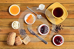 Crispy rolls with butter, apple jelly and hot tea for breakfast