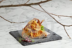 Crispy Soft Shell Crab tossed with Salted Egg Yolk served in a dish isolated on grey background