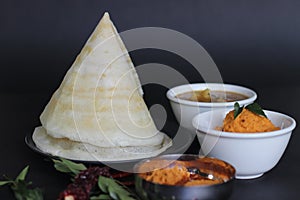Crispy thin ghee dosa with sambar, coconut chutney and Molaha Podi. Dosa is served in tent shape. A South Indian breakfast