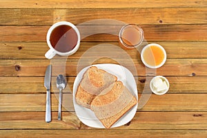 Crispy toast with butter, apple jelly and hot tea for breakfast