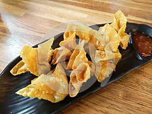 Deep Fried Wonton on black dish with plum sauce photo