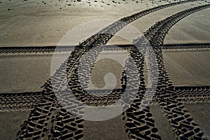 Criss cross 4WD vehicle tyre tracks on a beach, New Zealand