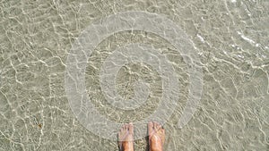 Cristal Clear Sea Water up close with feet, Water Surface, Water wave smooth texture