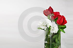 Cristal glass jar with some water and red roses and white flowers. Empty copy space