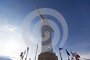 Cristo del Rey statue of Cali with world flags and blue sky, Col