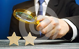 A critic holds a magnifying glass over two stars. Rating, feedback and review of a restaurant or hotel. Quality of service.