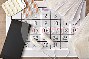 Critical days marked on calendar with phone and menstrual products