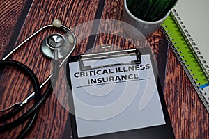 Critical Illness Insurance write on paperwork isolated on wooden table photo