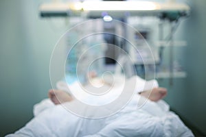 Critically ill patient in ICU ward, blurred medical background photo