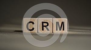 CRM, customer relationship management, loyalty program, repeat purchase frequency concept, on wooden blocks over gray background