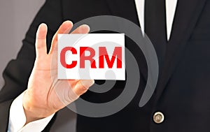 CRM letters or Customer Relationship Management on the card shown by a businessman