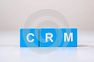 CRM text Customer Relationship Management cube blocks on table background. Financial, marketing and business concepts