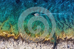 Croatia. Boat at the sea surface. Aerial view of floating boat on blue Adriatic sea at sunny day.