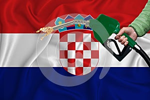 CROATIA flag Close-up shot on waving background texture with Fuel pump nozzle in hand. The concept of design solutions. 3d