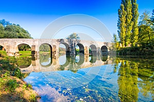 Croatia, river Dobra and old stone bridge in Novigrad