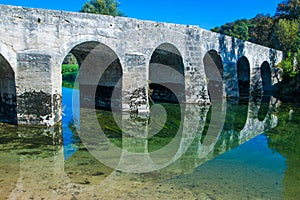 Croatia, river Dobra and old stone bridge in Novigrad