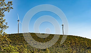 Croatia.Wind turbines standing on a hill against a clear blue sky.