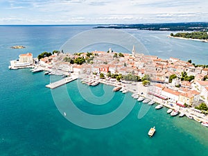 Croatian town of Porec, shore of blue azure turquoise Adriatic Sea, Istrian peninsula, Croatia. Bell tower, red tiled roofs. photo