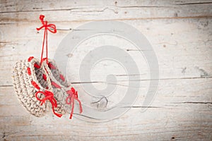 Crochet baby booties on wooden background