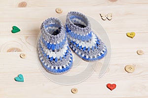 Crochet Baby Booties on wooden background