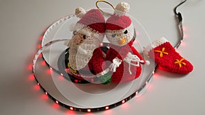 crochet christmas snowman on white background with usb led lights on the scroll, flashing and static red, blue, green